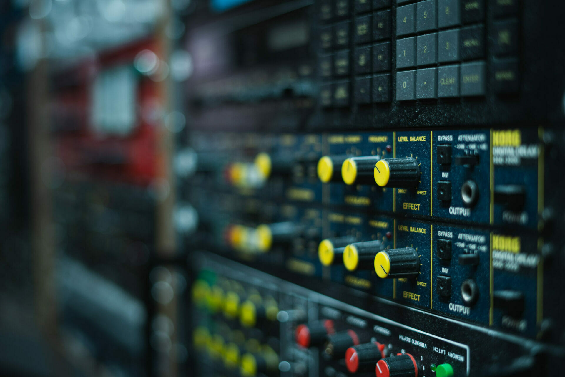 Close-up of a sound mixing board at MOON MUTT Recording Studio in Roswell, New Mexico, with various knobs and sliders for audio control. | MOON MUTT Recording Studio
